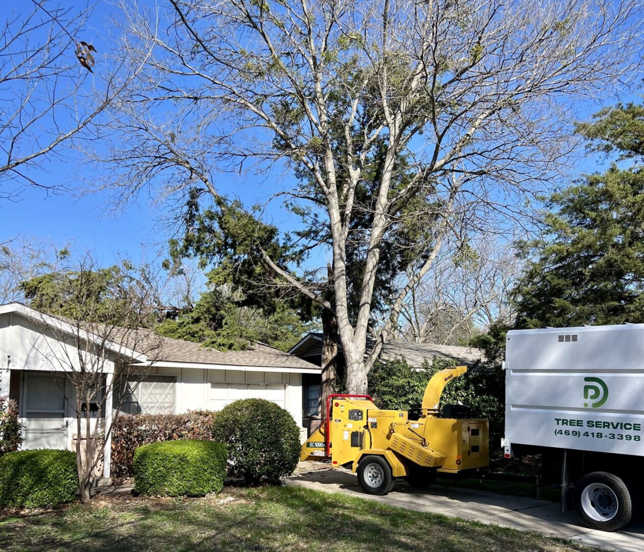A tree removal truck parked in front of a house.